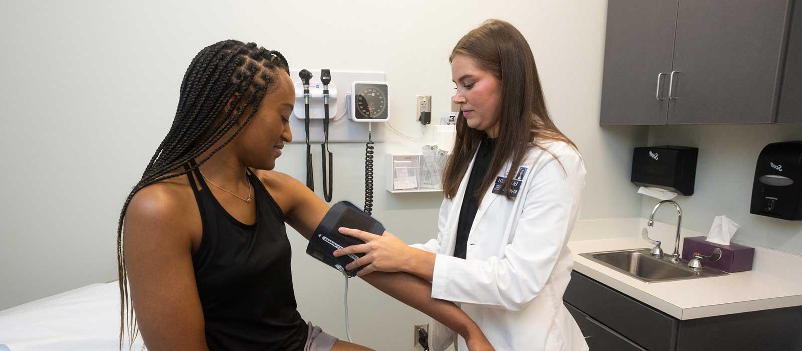 A medical student at the Whiddon College of Medicine practices taking blood pressure.