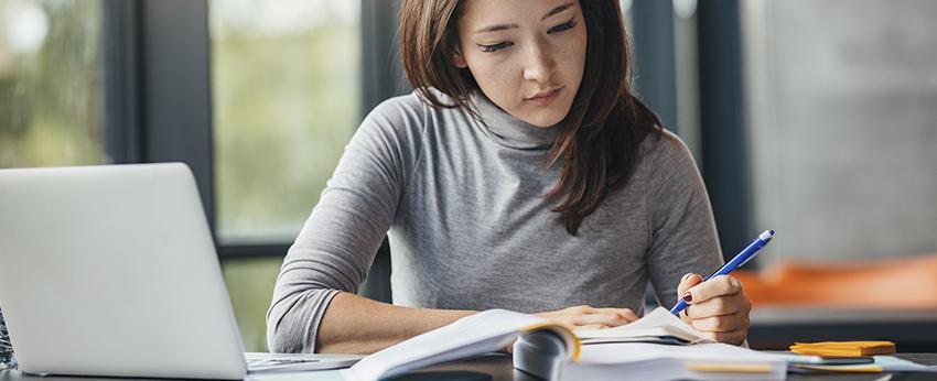 Female at desk writing on paper